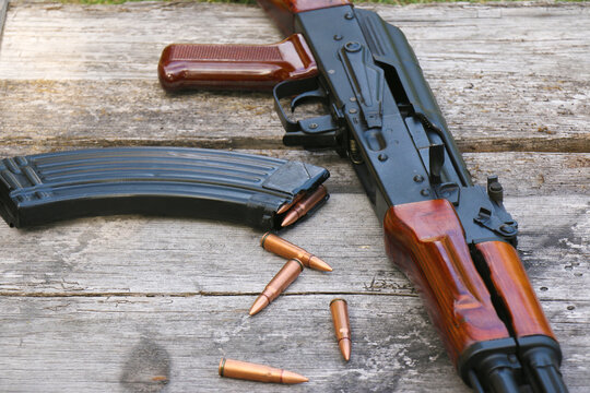 The famous Soviet assault rifle with magazine and cartridges on an old, damaged board