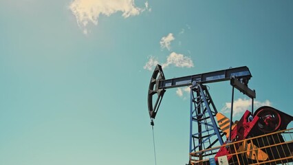Low angle view of oil pump jack. Drilling derrick for fossil fuels output and crude oil production. Crude oil industry, background with pump jacks, drill rigs.
