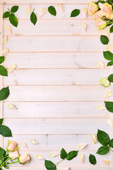 Frame forming rose flowers and leaves as a wedding template on wooden board background