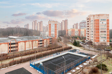 Modern apartments city building green residential area with basketball court and warehouse buildings blue cloudy sky background © svetlana