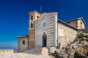 The small village of Tolfa, in Lazio. The Sanctuary of the Madonna della Rocca on top of the cliff,...