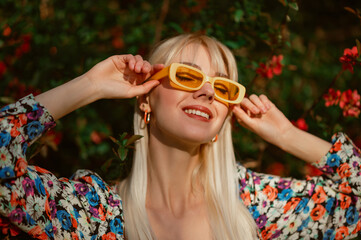 Spring, summer fashion conception: joyful blonde woman wearing trendy yellow rectangle sunglasses...
