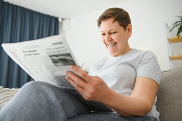 woman reading newspaper at home