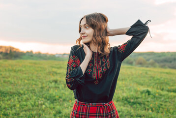horizontal portrait of young beautiful Ukrainian woman in vyshyvanka  - ukrainian national clothes outdoors in countryside during sunset. Stand with Ukraine  