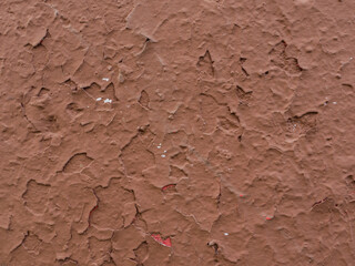 Peeling brown plaster on the wall.