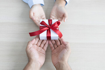 Young man's hand holds a gift box to a young woman on festival day, Christmas surprise, New year's surprise, Surprise important day, Birthday surprise, Gift box.