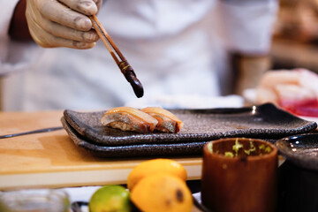 Selective Focus on the omakase sushi that's preparing by a unidentify chef.