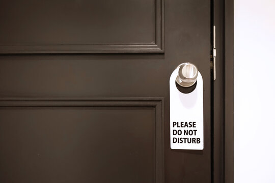 PLEASE DO NOT DISTURBと書かれた札をかけたホテルのドア
