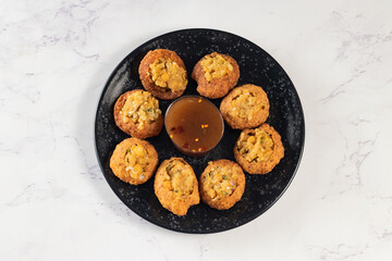 Pakistani spicy gol gappay, indian pani puri and bangali fuchka full of chaat masala with sour water in a dish isolated on marble background top view of indian street food - obrazy, fototapety, plakaty