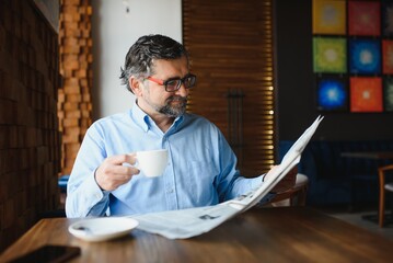 Business man reading a newspaper, cafe backgrounds