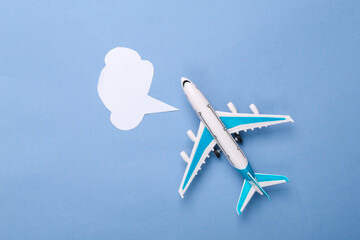 Toy air plane with empty dialogue bubble on blue background. Top view