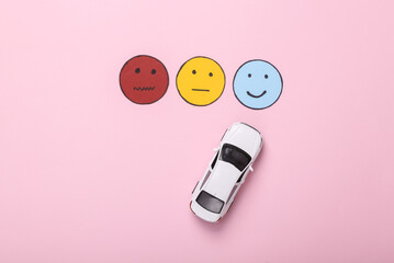 Logistics, taxi or car sharing service. Customer satisfaction survey concept. Toy car choice happy face icon, neutral and sad face paper icon on pink background. Top view