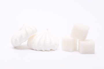 Fototapeta na wymiar Sweet white meringue and sugar cubes isolated on a white background.