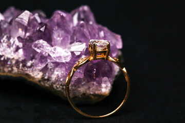 Gold ring with diamond on natural amethyst druse. Isolated on black background