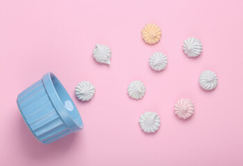 Bowl with Sweet colored meringue on a pink background. Top view. Flat lay
