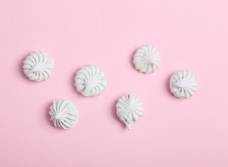 Sweet meringue on a pink background. Top view. Flat lay