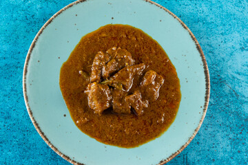 Beef masala curry in a plate isolated on background top view of indian, pakistani and bangali food
