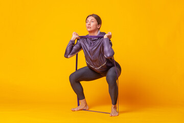 Sport woman trainin on yellow studio background