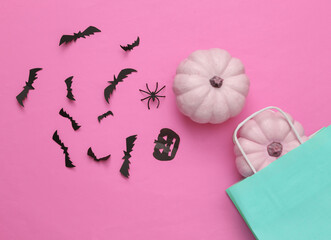 Shopping paper bag with Halloween decor on pink background. Halloween shopping. Top view