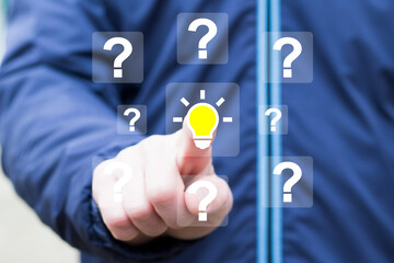 Businessman hand presses button with question mark symbol and light bulb icon. Concept creative idea and innovation.