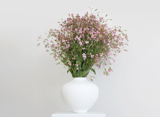 Pink flower bouquet in white vase on gray interior. Minimalist still life. Light and shadow nature horizontal background.