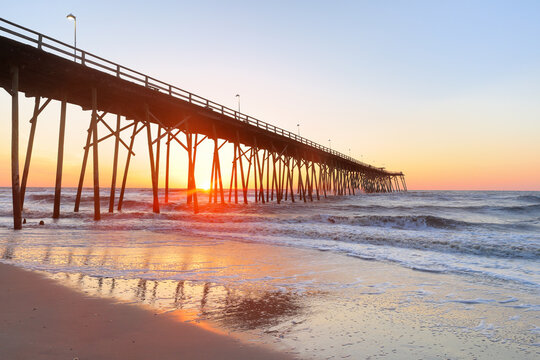 Kure Beach Fishing Pier at sun rise, Kure Beach, North Carolina, USA. Kure beach is the home to the oldest fishing pier on the Atlantic Coast and an oceanfront park.