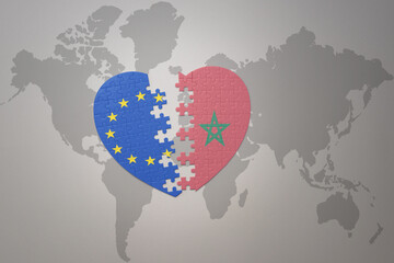 puzzle heart with the national flag of european union and morocco on a world map background. Concept.