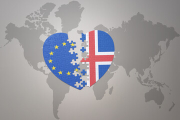 puzzle heart with the national flag of european union and iceland on a world map background. Concept.