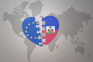 puzzle heart with the national flag of european union and haiti on a world map background. Concept.