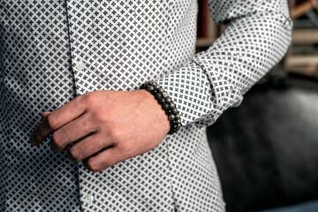Business style, men's bracelets on the hand. White shirt, close-up
