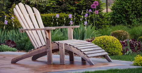 Drewniany fotel ogrodowy na tarasie w pięknym ogrodzie. Strefa wypoczynku na tarasie ogrodowym - obrazy, fototapety, plakaty