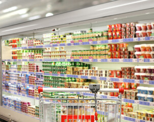 choosing a dairy products at supermarket.empty grocery cart in an empty supermarket