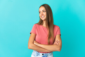 Young woman over isolated blue background happy and smiling