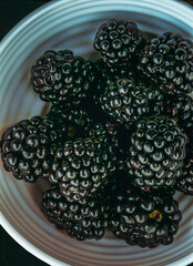 Blackberries . Sweet and juicy berry. Heap of blackberries in a plate. Black berry. Top view. Close-up.