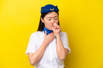 Airplane Chinese woman stewardess isolated on yellow background is suffering with cough and feeling bad