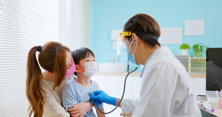 pediatrician examining sick boy