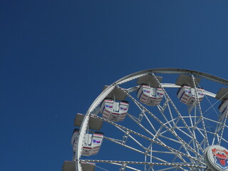 A gorgeous sunlit day at Old Orchard Beach on the Maine coast, offers sunbathing, swimming and the tourist attractions along the pier, like this ferris wheel.  - 505989863