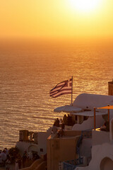 Fototapeta premium Greek flag near Aegean sea during sunset.