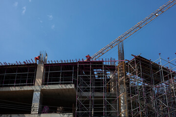 Bottom view of a building under construction against a clear sky background.