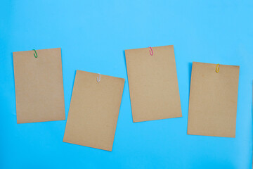 Brown paper with clip on blue background.