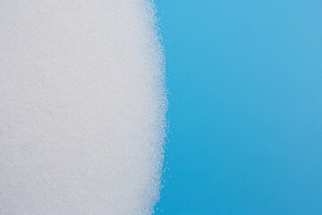 White sugar on blue background.