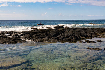 Woman Kayaking and Tide Pool On The Volcanic Shoreline of Keiki Beach, Kailua-Kona, Hawaii Island, Hawaii, USA