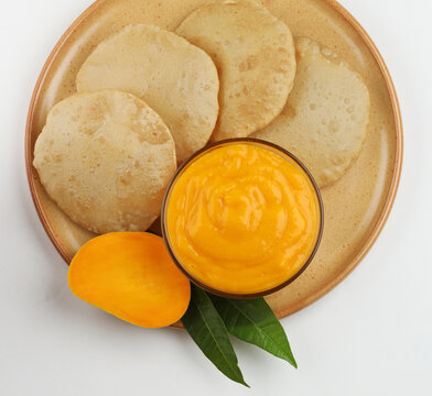 Aam Ras Puri is a delicious Indian recipe served as a seasonal Dessert, Aamras is plain Haapus or Alphonso Mango Puree/Pulp served with puri. selective focus