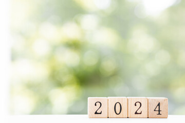 Wooden cubes with 2024 and happy new year over wooden background, banner with copy space for text, new year greeting card template