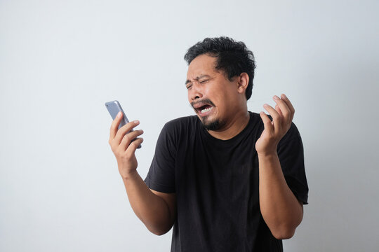 Sad Young Asian Man Crying While Holding Phone