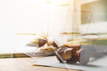 Justice and law concept.Male judge in a courtroom with the gavel, working with, computer and docking keyboard, eyeglasses, on table in morning light