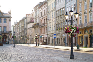 Traditional houses on a pedestrian street in the historic Old Town of Lviv, Ukraine. lanterns and many flowers. May 2021