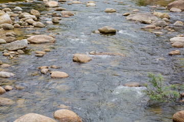 The flow of water in the waterfall stream crashes through the rocks.