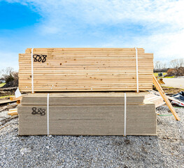 New lumber plank and siding board with white stripes stacking on the ground. Pile of exterior...