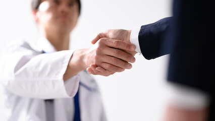 医療従事者と握手を交わすビジネスマン